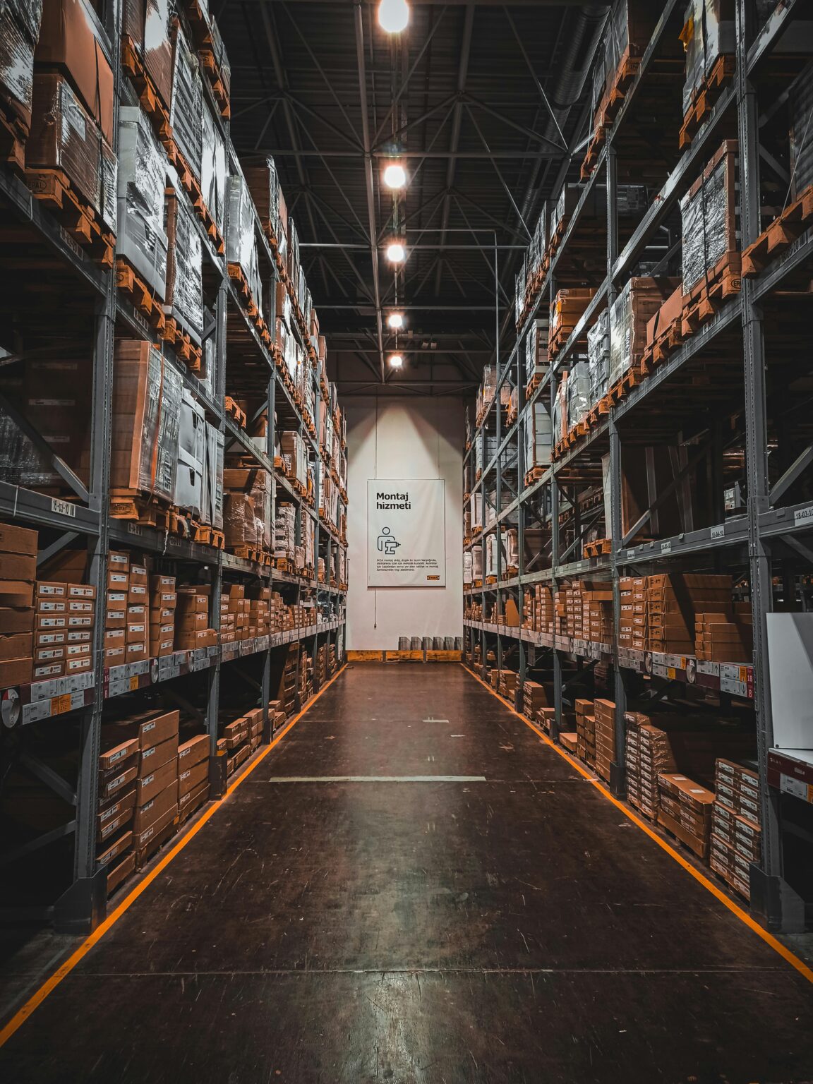 Magazijn overzichtelijk ingericht met gele vloermarkeringen, duidelijke looproutes en georganiseerde opslagzones voor efficië